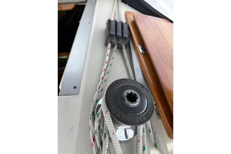Slide: The Image of Close-up of sailing equipment on a 1988 Pearson 28 yacht, featuring ropes and a winch. - 10