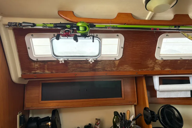 Slide: The Image of Interior of a 1988 Pearson 28 sailboat with fishing rod storage and wooden cabinetry. - 13