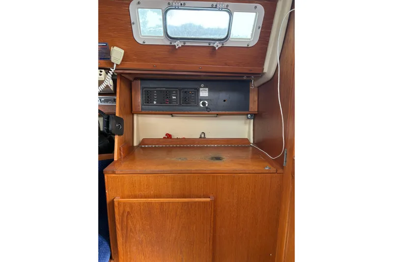 Slide: The Image of 1988 Pearson 28 sailboat interior with wooden cabinetry and control panel. - 16