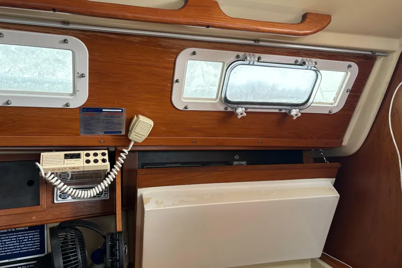 Slide: The Image of Interior of a 1988 Pearson 28 sailboat with wooden paneling and communication equipment. - 17