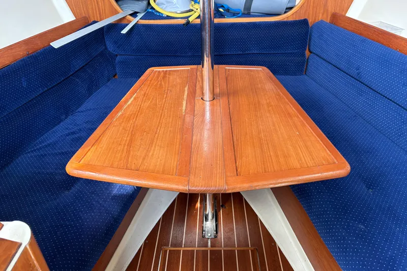 Slide: The Image of Interior of 1988 Pearson 28 sailboat with wooden table and blue cushioned seating. - 21