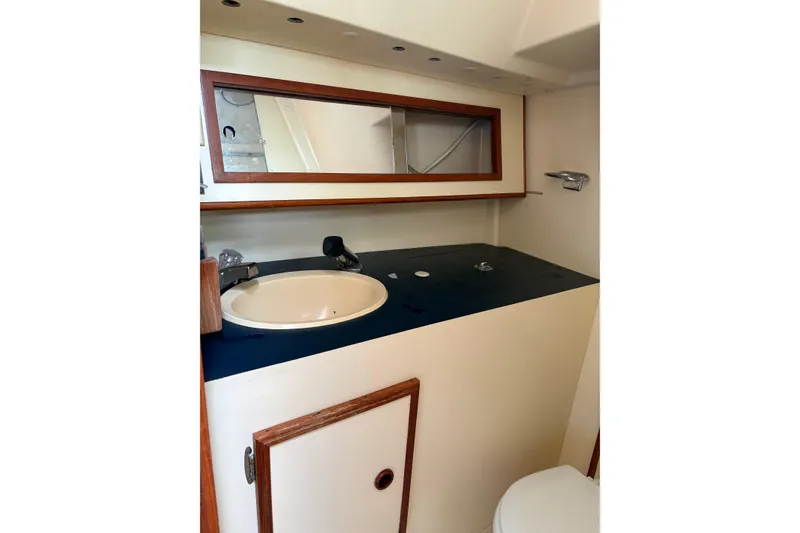 Slide: The Image of 1988 Pearson 28 yacht bathroom with sink, mirror, and storage cabinet. - 30