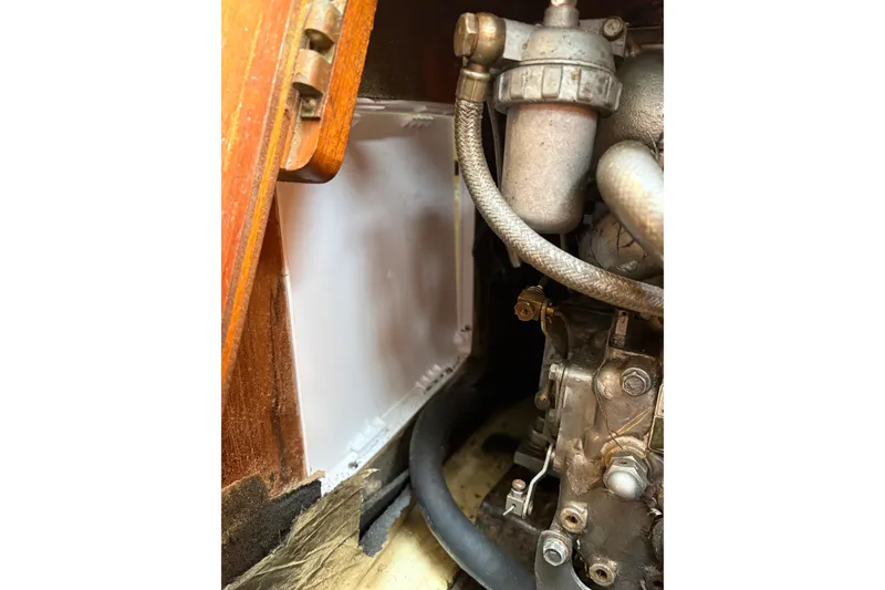 Slide: The Image of Engine compartment of a 1988 Pearson 28 sailboat, showcasing mechanical components and hoses. - 36