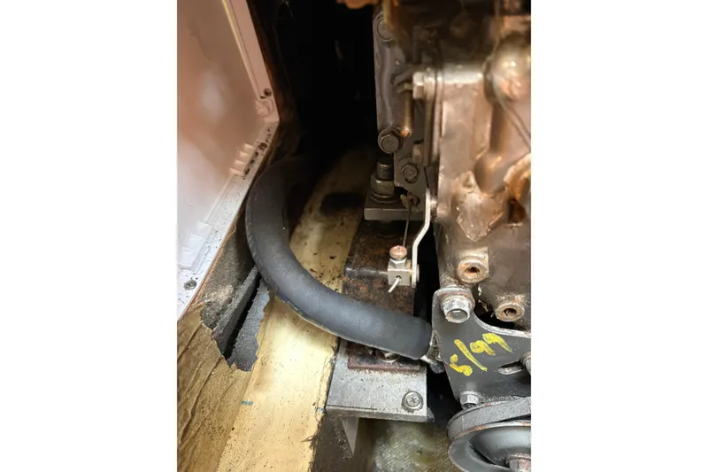 Slide: The Image of Engine compartment of a 1988 Pearson 28 sailboat, showing mechanical components and hoses. - 37