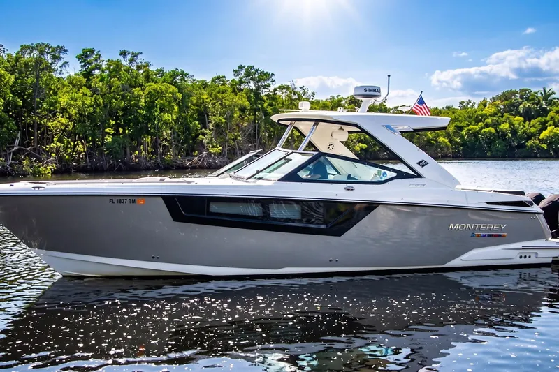 Slide: The Image of 2022 Monterey 385SS Super Sport boat on a sunny day, cruising on a serene river. - 15