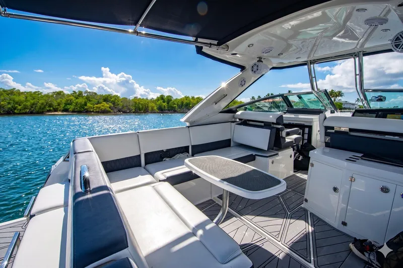 Slide: The Image of Luxurious 2022 Monterey 385SS Super Sport boat interior with seating and table on a sunny day. - 16
