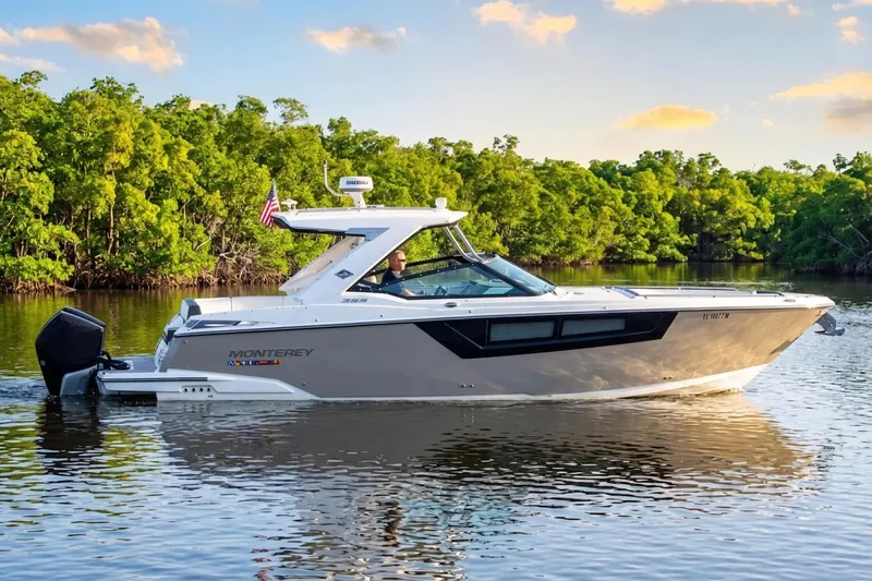 Slide: The Image of 2022 Monterey 385SS Super Sport boat cruising on a serene river with lush greenery. - 22