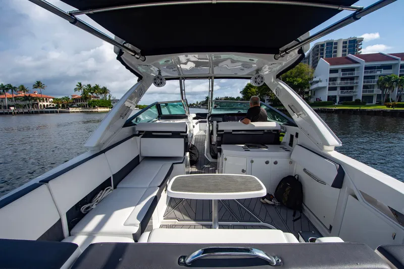 Slide: The Image of 2022 Monterey 385SS Super Sport boat interior with seating and table on a sunny day. - 27
