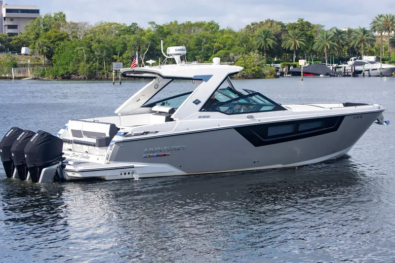 Slide: The Image of 2022 Monterey 385SS Super Sport boat on a calm river with lush greenery. - 3