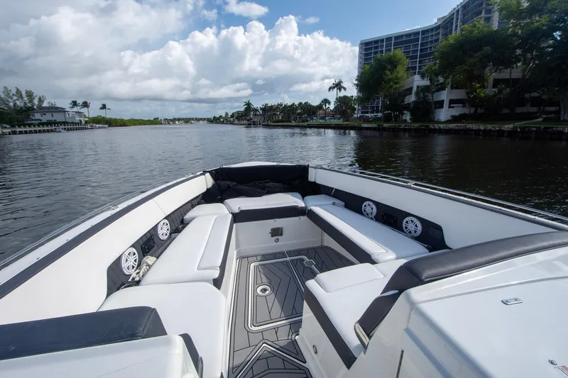 Slide: The Image of 2022 Monterey 385SS Super Sport boat interior with luxurious seating on a scenic waterway. - 30