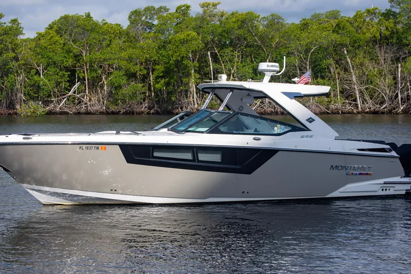 Slide: The Image of 2022 Monterey 385SS Super Sport boat cruising on a calm river with lush greenery. - 7