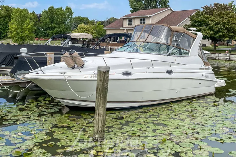 The Image of 1998 Cruisers Yachts 2870 Rogue docked in a serene, lily-covered marina. - 0