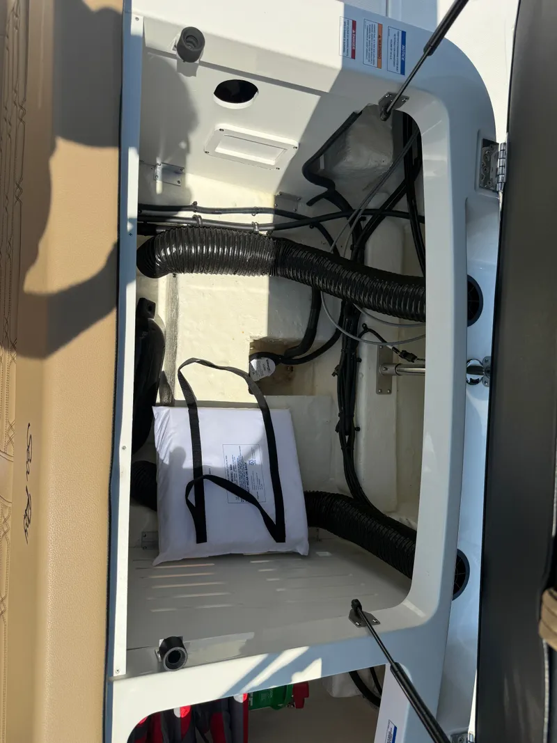 Slide: The Image of Interior of 2025 Sea Ray SPX 190 Outboard showing storage and cables. - 24