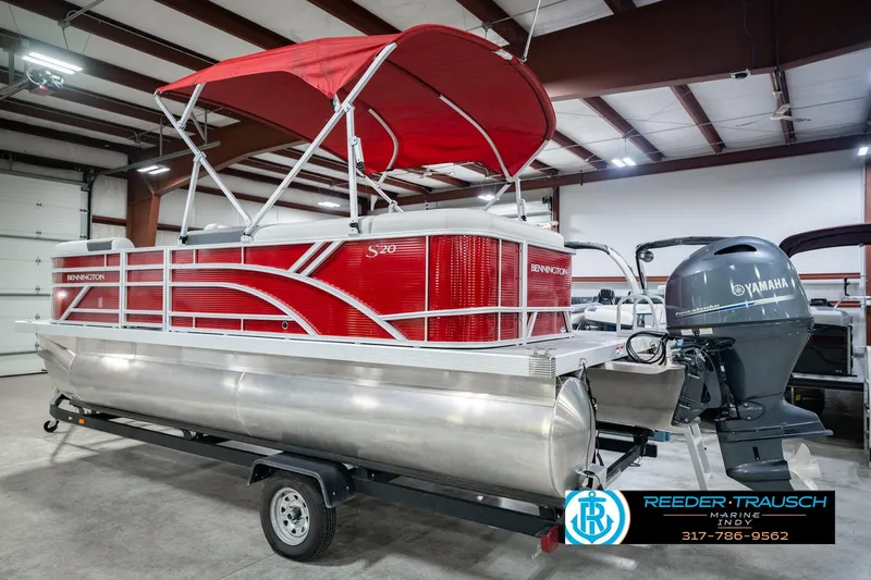 Slide: The Image of 2025 Bennington 20 SLS pontoon boat with red canopy and Yamaha outboard motor in showroom. - 11