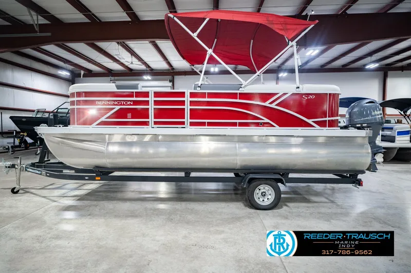 Slide: The Image of 2025 Bennington 20 SLS pontoon boat with red canopy on trailer in showroom. - 13
