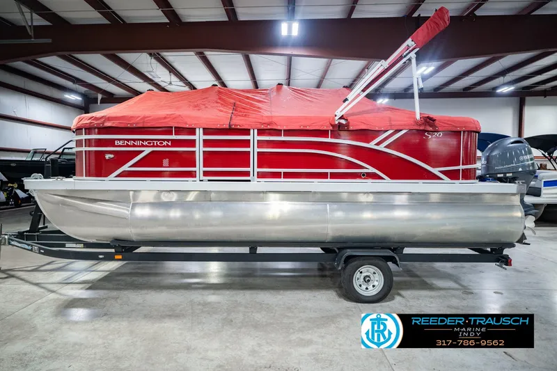 Slide: The Image of 2025 Bennington 20 SLS pontoon boat with red cover on trailer in showroom. - 64