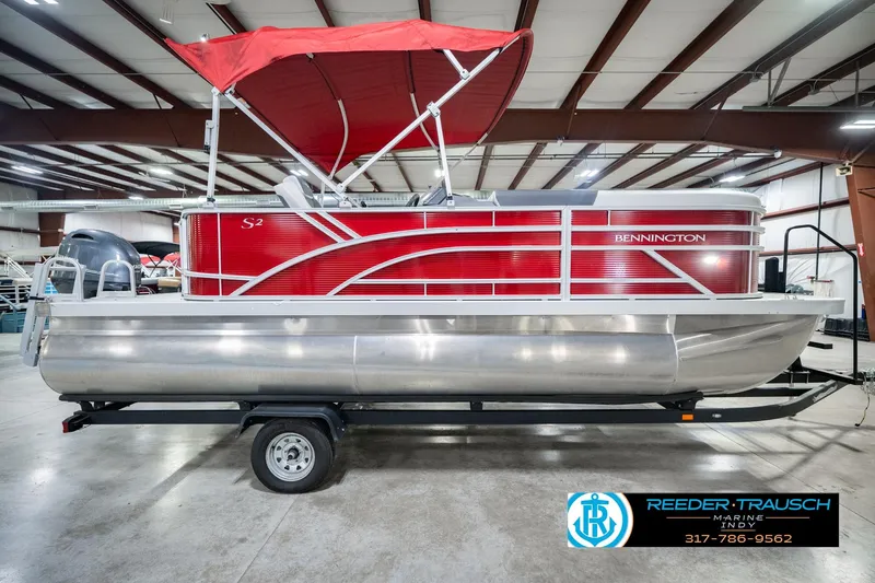 Slide: The Image of 2025 Bennington 20 SLS pontoon boat with red canopy in showroom. - 7