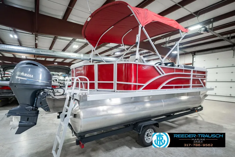 Slide: The Image of 2025 Bennington 20 SLS pontoon boat with red canopy and Yamaha motor in showroom. - 9
