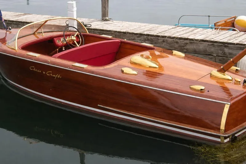 The Image of 1956 Chris-Craft Capri 21 classic wooden boat docked on calm water. - 1