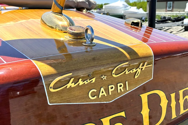 Slide: The Image of 1956 Chris-Craft Capri 21 boat with polished wood finish and logo detail. - 11
