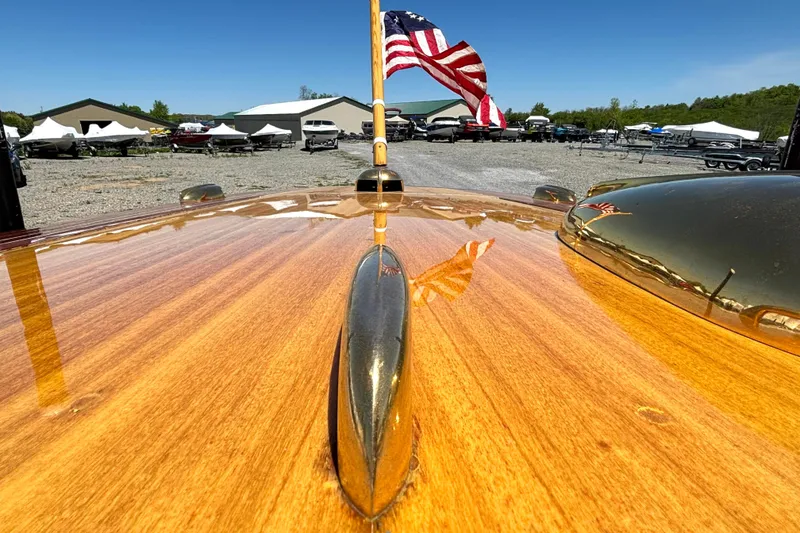 Slide: The Image of 1956 Chris-Craft Capri 21 with polished wood finish and American flag. - 13