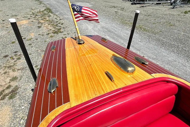 Slide: The Image of 1956 Chris-Craft Capri 21 boat with polished wood deck and American flag. - 14