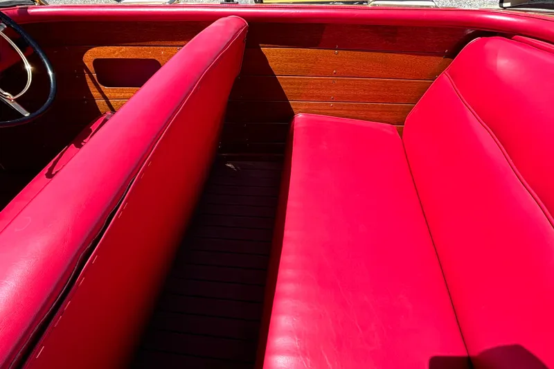 Slide: The Image of 1956 Chris-Craft Capri 21 interior with vibrant red seating and wooden paneling. - 16