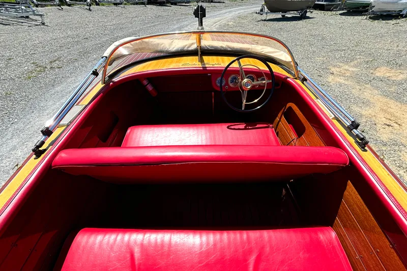 Slide: The Image of 1956 Chris-Craft Capri 21 boat interior with red leather seats and wooden dashboard. - 18