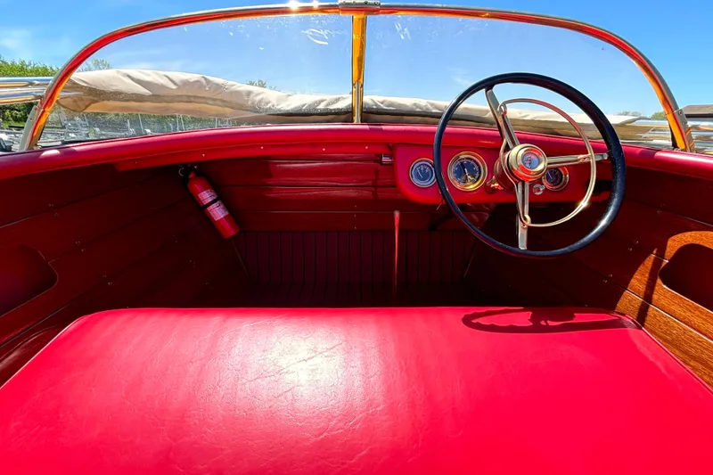 Slide: The Image of 1956 Chris-Craft Capri 21 boat interior with red upholstery and classic steering wheel. - 19