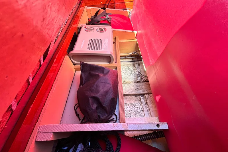 Slide: The Image of Storage compartment in a 1956 Chris-Craft Capri 21 boat with equipment and red interior. - 26