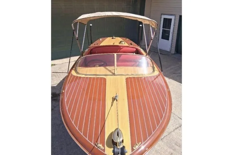 Slide: The Image of 1956 Chris-Craft Capri 21 classic wooden boat with canopy, showcasing elegant design and craftsmanship. - 3