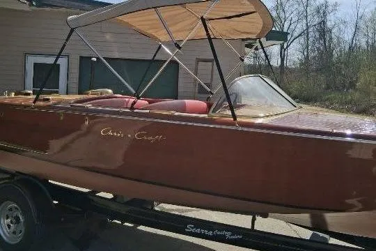 Slide: The Image of 1956 Chris-Craft Capri 21 boat with canopy on trailer, parked outdoors. - 38