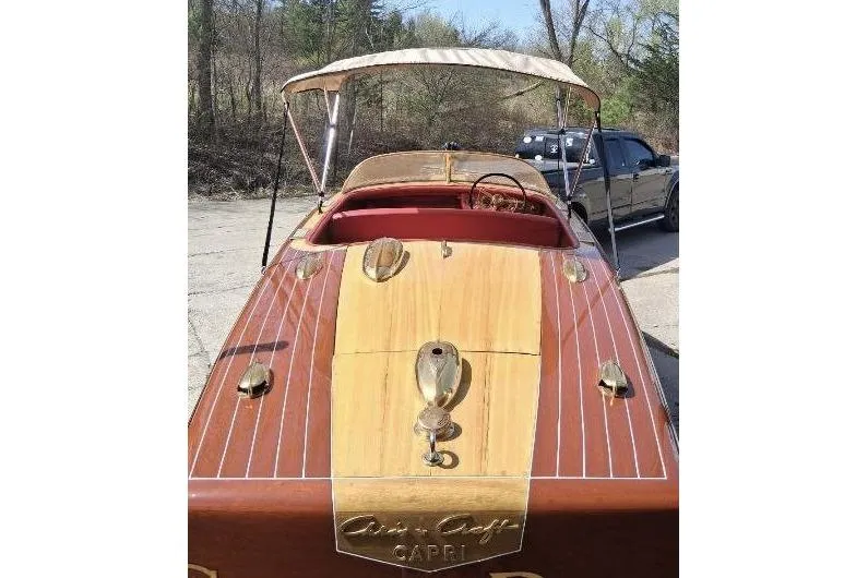 Slide: The Image of 1956 Chris-Craft Capri 21 classic wooden boat with canopy, parked outdoors. - 4