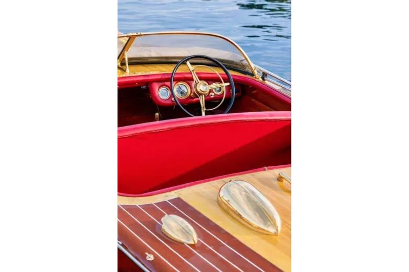 Slide: The Image of 1956 Chris-Craft Capri 21 boat interior with red dashboard and wooden accents. - 6