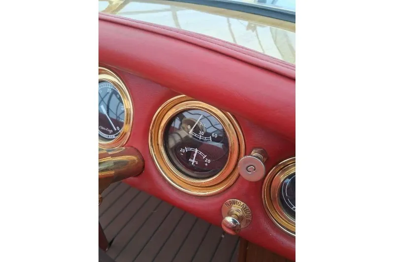 Slide: The Image of 1956 Chris-Craft Capri 21 dashboard with vintage gauges and red leather trim. - 8