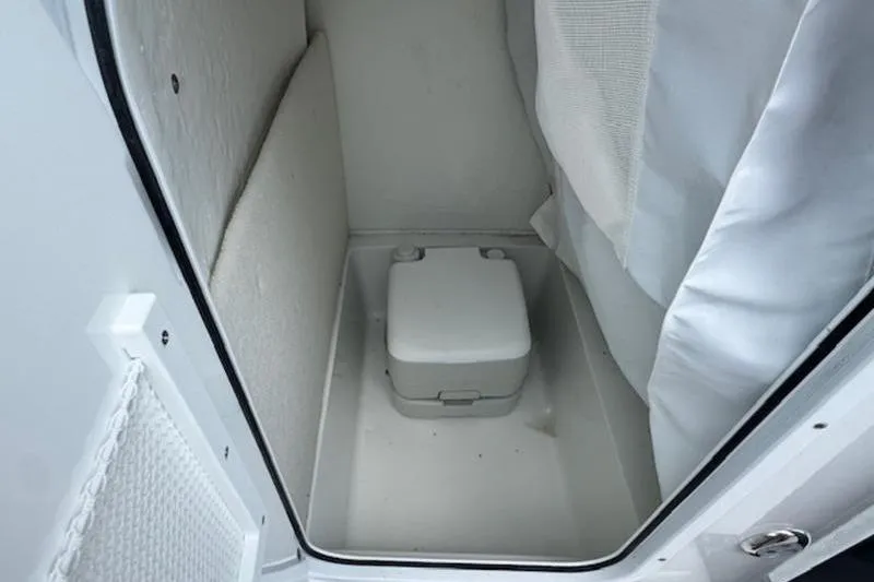 Slide: The Image of Interior of Sea Hunt Ultra 219, featuring a portable toilet. - 13