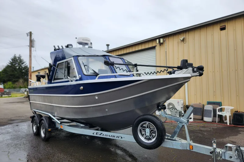 Slide: The Image of 2025 Thunder Jet 21 Chinook OS boat on trailer, parked outside a warehouse. - 11