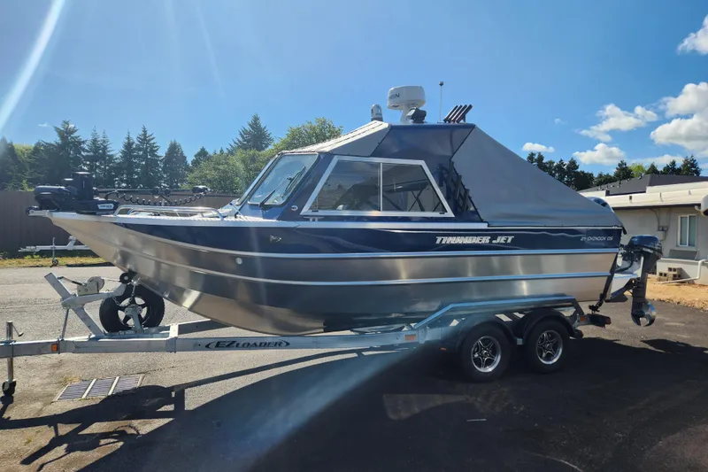 Slide: The Image of 2025 Thunder Jet 21 Chinook OS boat on trailer, parked outdoors under clear sky. - 25