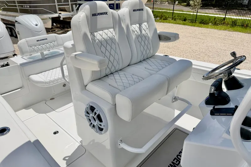 Slide: The Image of 2025 Bluewater 25t boat interior with white quilted seating and steering console. - 12