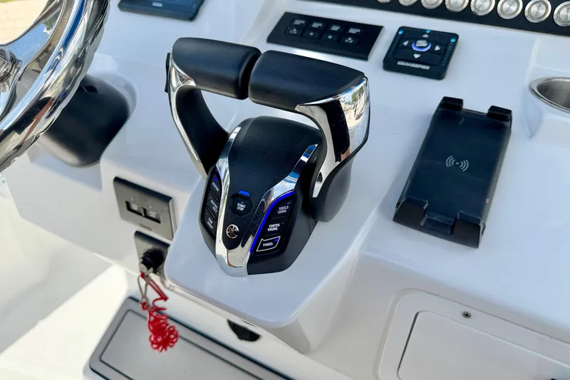 Slide: The Image of Control panel of 2025 Bluewater 25t boat with throttle and wireless charging pad. - 19