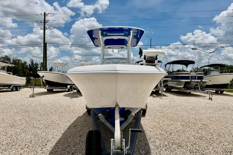 Slide: The Image of 2025 Bluewater 25t boat on trailer, displayed outdoors under a partly cloudy sky. - 2