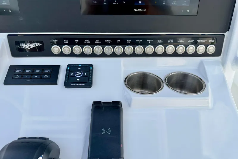 Slide: The Image of Control panel of 2025 Bluewater 25t boat with switches, cup holders, and Seakeeper device. - 21