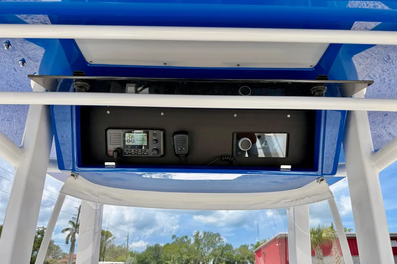Slide: The Image of Bluewater 25t 2025 boat console with radio and control panel, under blue canopy. - 22