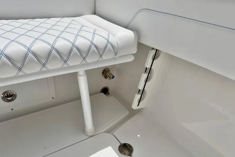 Slide: The Image of Interior of 2025 Bluewater 25t boat featuring white cushioned seating and storage compartments. - 28