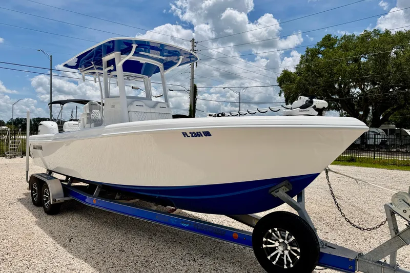 Slide: The Image of 2025 Bluewater 25t boat on trailer under blue sky, showcasing sleek design and modern features. - 3