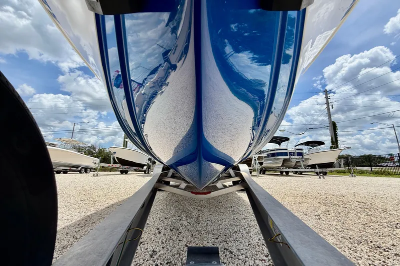 Slide: The Image of 2025 Bluewater 25t boat on trailer, showcasing sleek hull design under a cloudy sky. - 33