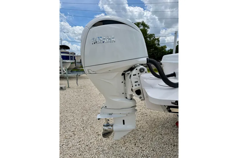 Slide: The Image of Yamaha outboard motor on 2025 Bluewater 25t boat, parked on gravel under cloudy sky. - 34