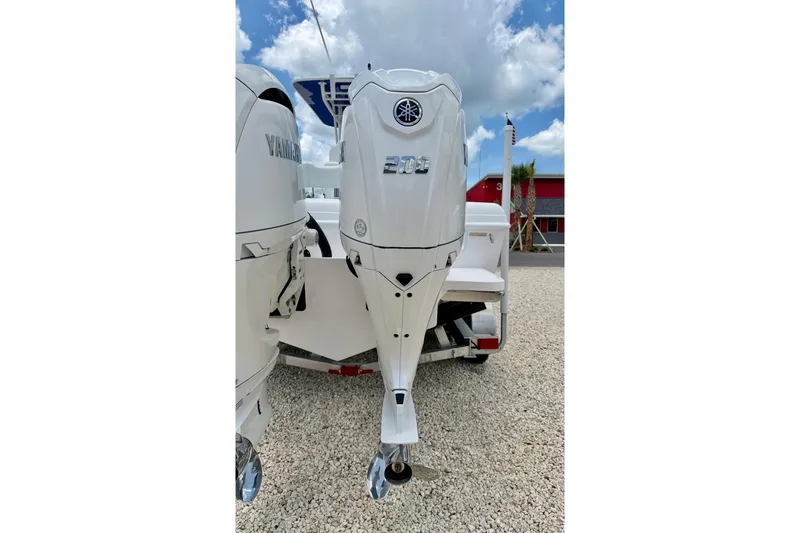 Slide: The Image of 2025 Bluewater 25t boat with Yamaha outboard motor, parked on gravel. - 35