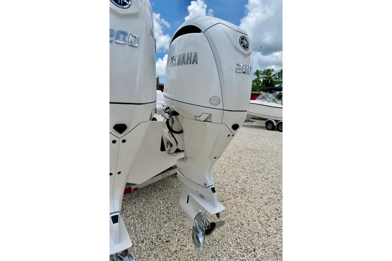 Slide: The Image of Twin Yamaha 300 outboard engines on a 2025 Bluewater 25t boat, parked on gravel. - 36