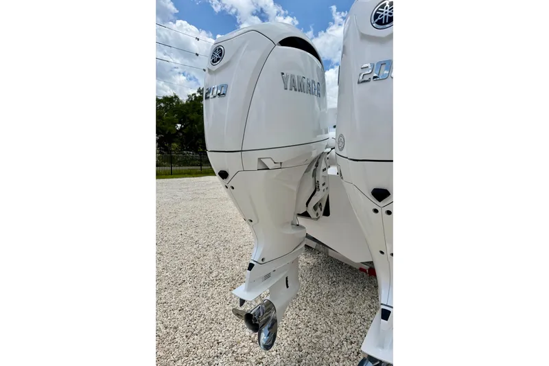 Slide: The Image of Twin Yamaha 200 outboard engines on a 2025 Bluewater 25t boat, parked on gravel. - 39